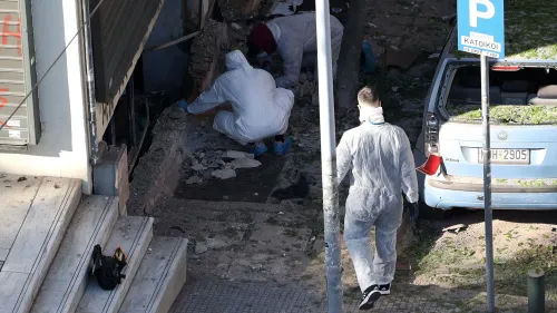 عمال الطوارئ يرتدون ملابس واقية يقومون بتفتيش موقع انفجار قنبلة في سالونيك، حيث تضررت واجهات المتاجر والمركبات.