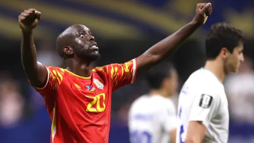لاعب منتخب الكونغو الديمقراطية يرفع يديه احتفالاً بعد تسجيل هدف في كأس العالم 2026، مرتدياً القميص الأحمر رقم 20.