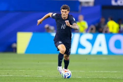 لاعب كرة قدم أمريكي يرتدي القميص رقم 10، يركض بسرعة خلال مباراة في كأس العالم، مع خلفية تظهر شعار الفيفا.