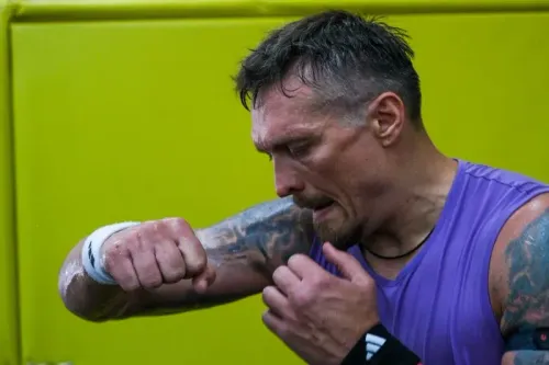 أولكسندر أوسيك، بطل العالم في الوزن الثقيل، يتدرب في صالة رياضية، مع التركيز على تدريباته في أجواء تعكس ارتباطه بأوكرانيا.