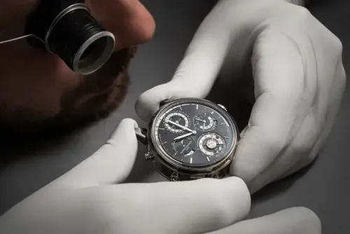 ساعة فاشرون كونستانتين الجديدة تُظهر تعقيدات ميكانيكية متعددة، مع صانع ساعات يرتدي قفازات بيضاء، يركز على تفاصيل الساعة.