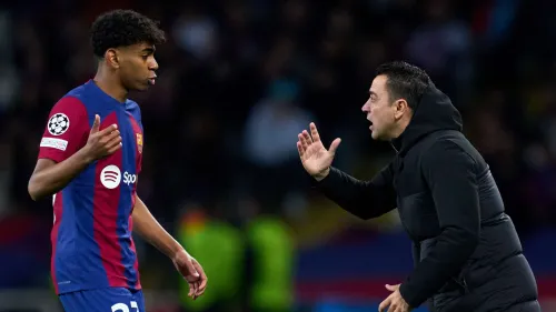 تشافي هيرنانديز يتحدث بحماس مع لامين يامال لاعب برشلونة الشاب خلال مباراة، مع التركيز على دعم موهبة يامال الصاعدة في كرة القدم العالمية.