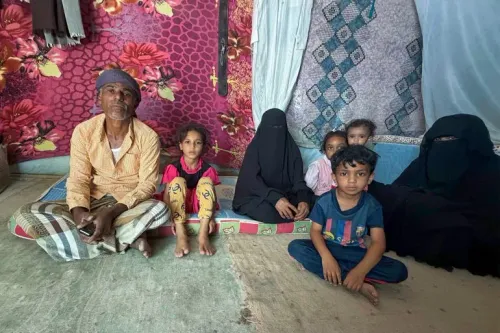 عائلة نازحة تجلس داخل خيمة في مخيم مريمة، وملامح المعاناة واضحة على وجوههم، في ظل ظروف معيشية صعبة وانعدام الأمن الغذائي.