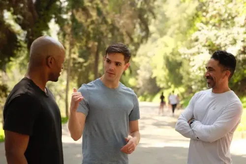 ثلاثة رجال يتحدثون في ممر طبيعي، يعبرون عن آرائهم حول السياسة والديمقراطيين الشباب في إنديانا.