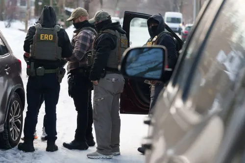 عملاء فيدراليون يرتدون سترات واقية يتجمعون في منطقة ثلجية، مع التركيز على تنفيذ عمليات التحقق من الهوية في مينيابوليس.