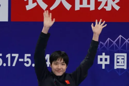 يو زيدي، السباحة الصينية البالغة من العمر 12 عامًا، ترفع يديها احتفالًا بعد تحقيق أوقات مذهلة في السباحة، مرشحة للمنافسة في بطولة العالم.