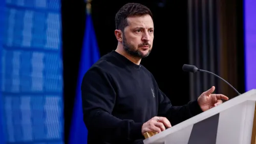 زيلينسكي يتحدث في مؤتمر صحفي، معبرًا عن أسر جنود كوريين شماليين في كورسك، خلفه علم أوكراني.