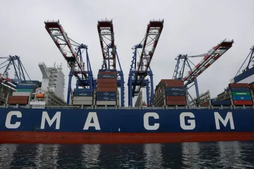 سفينة شحن CMA CGM محملة بالحاويات، راسية في ميناء مع وجود رافعات تحميل، تعكس انخفاض حركة الشحن من الصين إلى الولايات المتحدة.