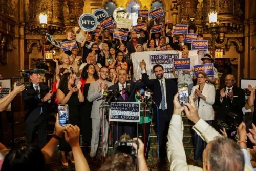 احتفال زهران ممداني بفوزه في الانتخابات التمهيدية للحزب الديمقراطي في نيويورك، مع أنصاره الذين يحملون لافتات دعمه.