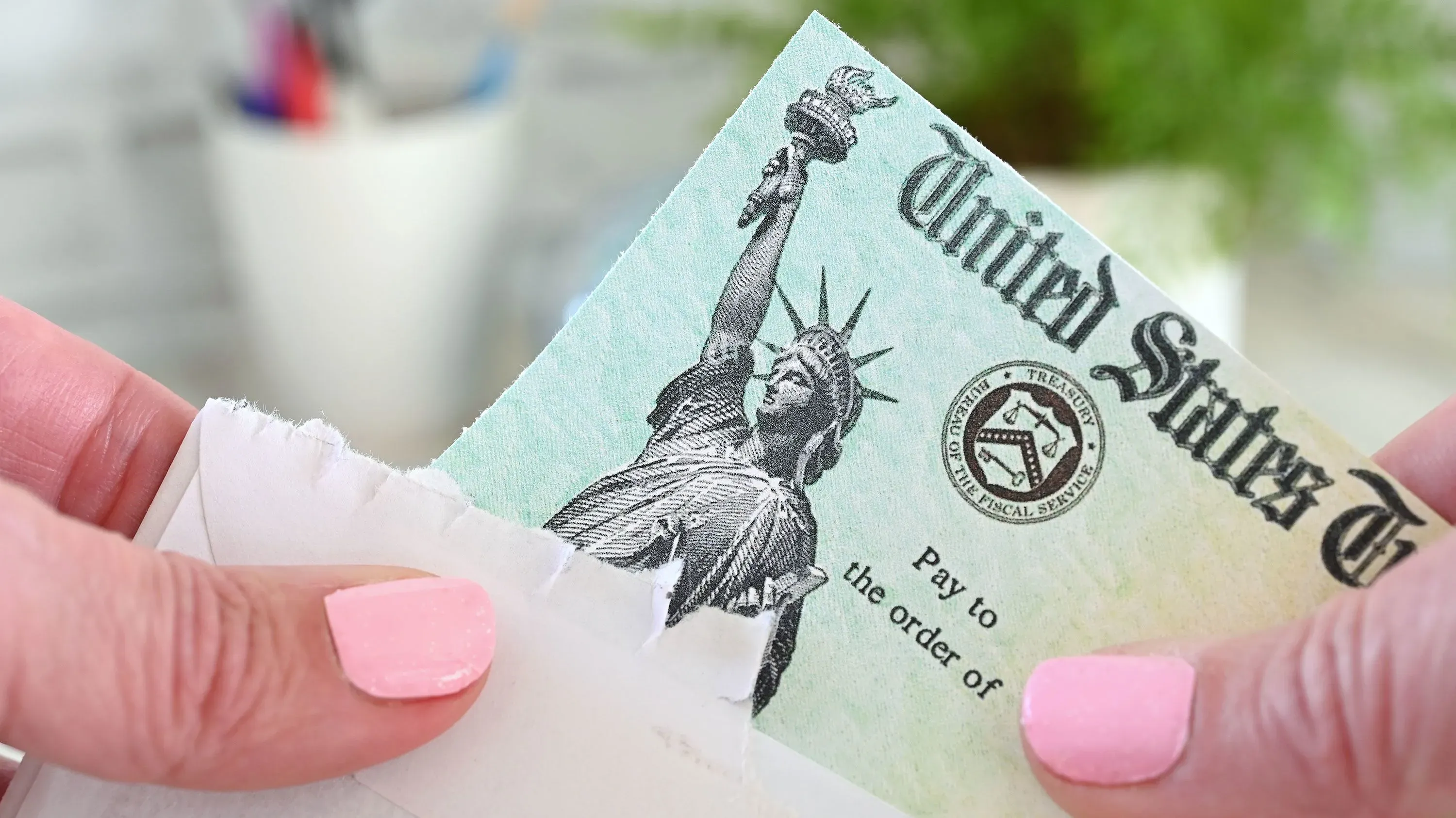 شيك حكومي أمريكي يظهر تمثال الحرية، يرمز إلى المزايا المالية للضمان الاجتماعي وتأثيرها على المتقاعدين والأشخاص ذوي الإعاقة.