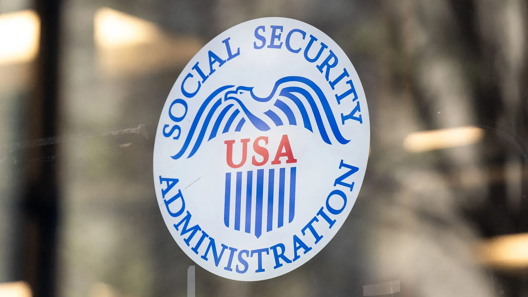 شعار إدارة الضمان الاجتماعي يظهر في نافذة مكتب، مع التركيز على التحديات الحالية في خدمة العملاء وزيادة المكالمات.