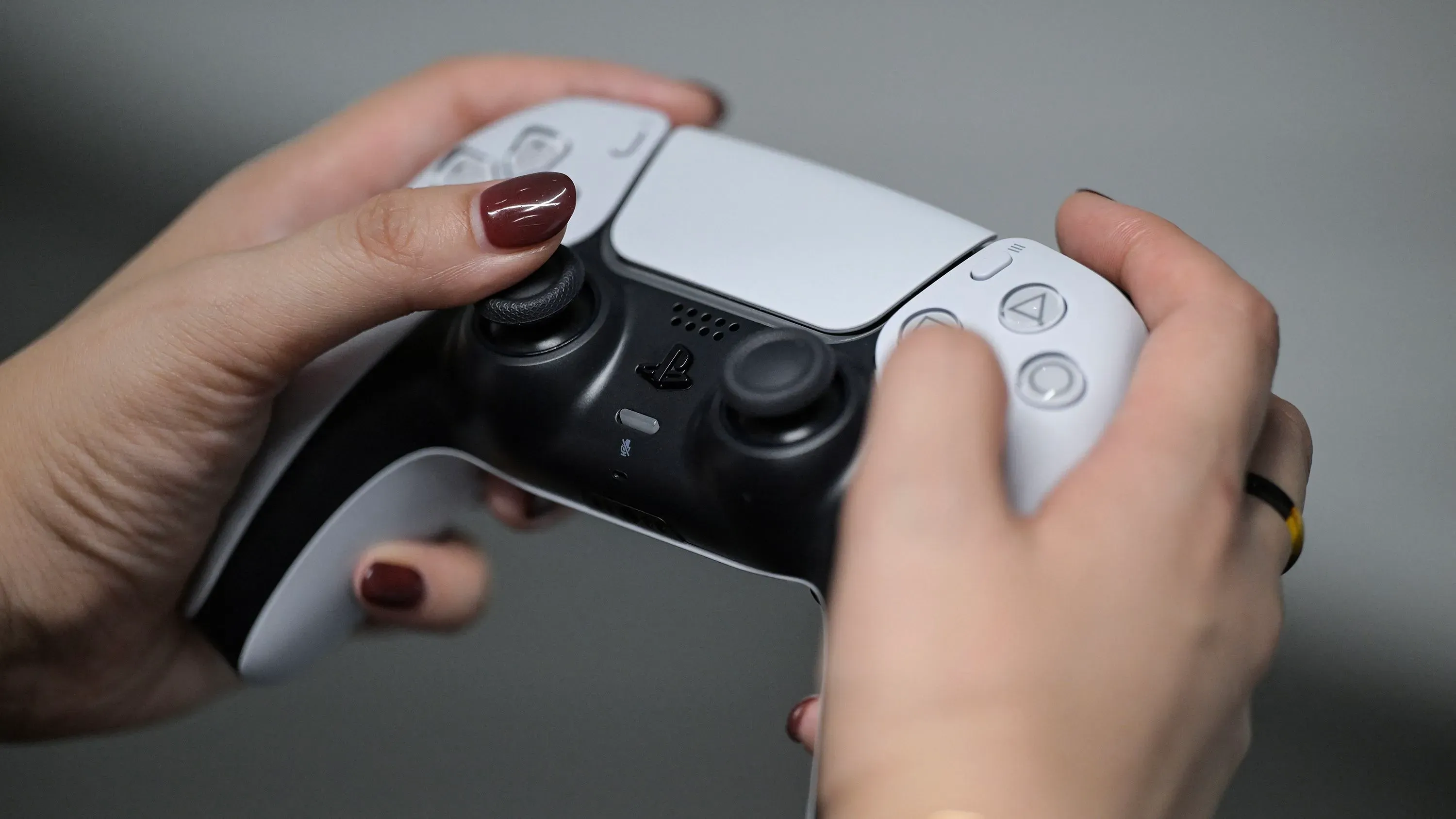 يد تظهر شخصًا يحمل وحدة تحكم بلاي ستيشن 5، في ظل انقطاع خدمات شبكة بلاي ستيشن، مما يؤثر على تجربة اللاعبين.