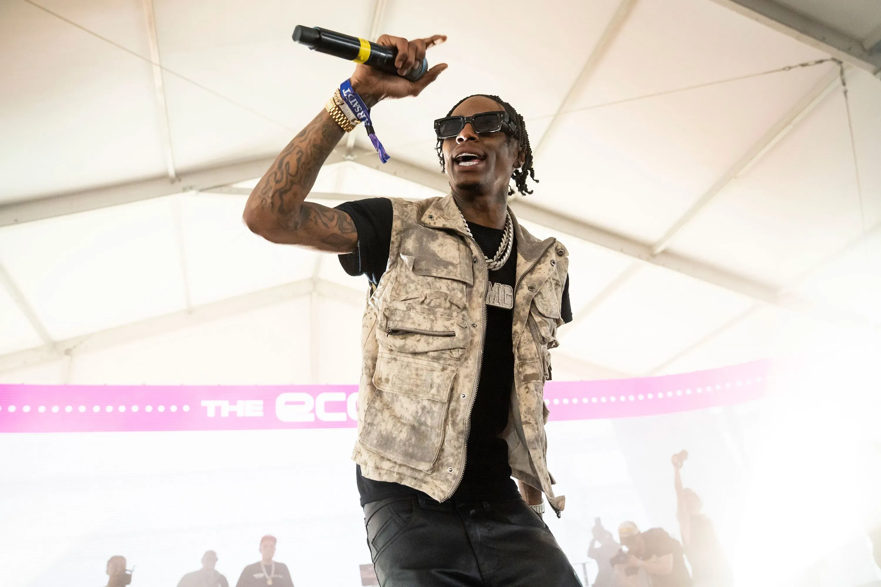 سولجا بوي يؤدي على المسرح، مرتديًا سترة بدون أكمام، ويشير بيده أثناء أدائه، وسط جمهور متحمس في الخلفية.