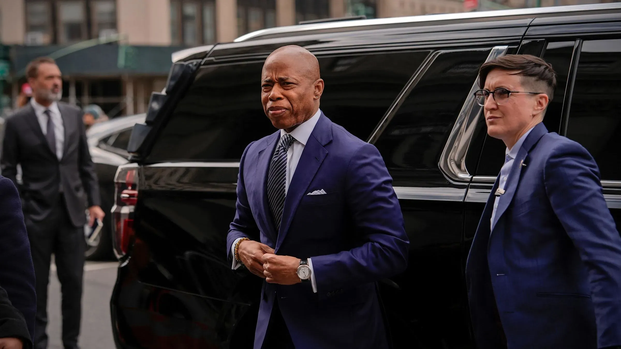 يظهر العمدة إريك آدامز وهو يغادر سيارة ليموزين، برفقة مساعدته، في سياق إعلان حاكمة نيويورك عن تغييرات إدارية جديدة.