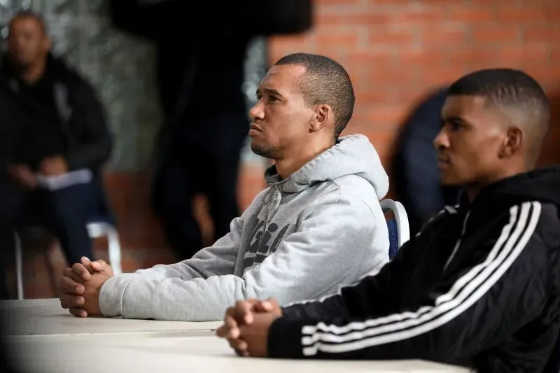 ثلاثة رجال يجلسون في قاعة المحكمة، يعبرون عن التوتر بعد إدانتهم في قضية اختطاف وتهريب طفلة في جنوب أفريقيا.