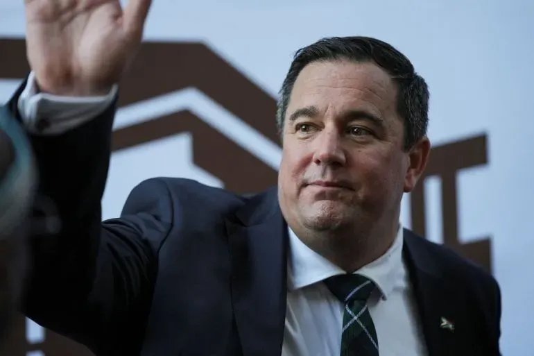 جون ستاينهاوزن، زعيم حزب التحالف الديمقراطي في جنوب أفريقيا، يلوح بيده خلال مؤتمر صحفي، معبرًا عن قلقه بشأن الفساد في الحكومة.