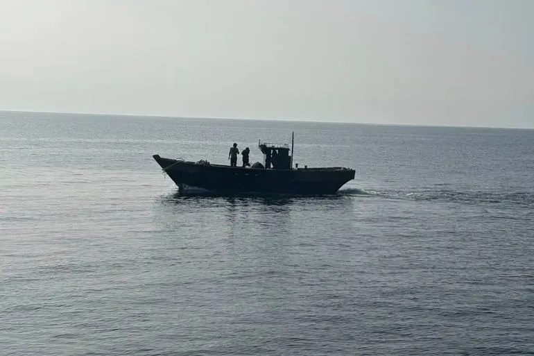 قارب في البحر يحمل ثلاثة أشخاص، يمثلون الكوريين الشماليين الذين تم إنقاذهم وإعادتهم إلى وطنهم، في سياق تحسين العلاقات بين الكوريتين.