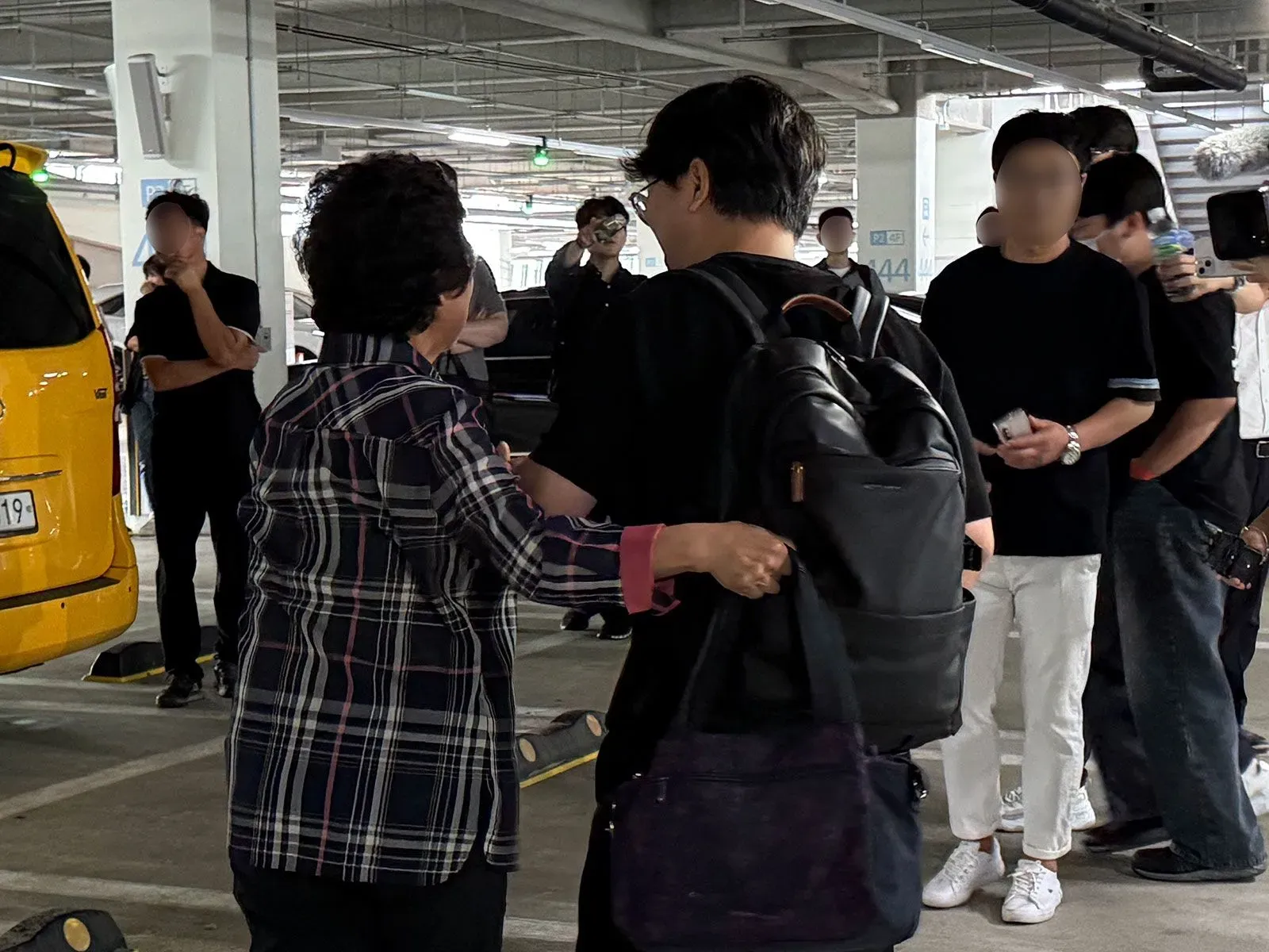 لم شمل عاطفي بين عائلة كورية جنوبية وعضو محتجز سابق، مع حشد من الصحفيين في مطار سيول.