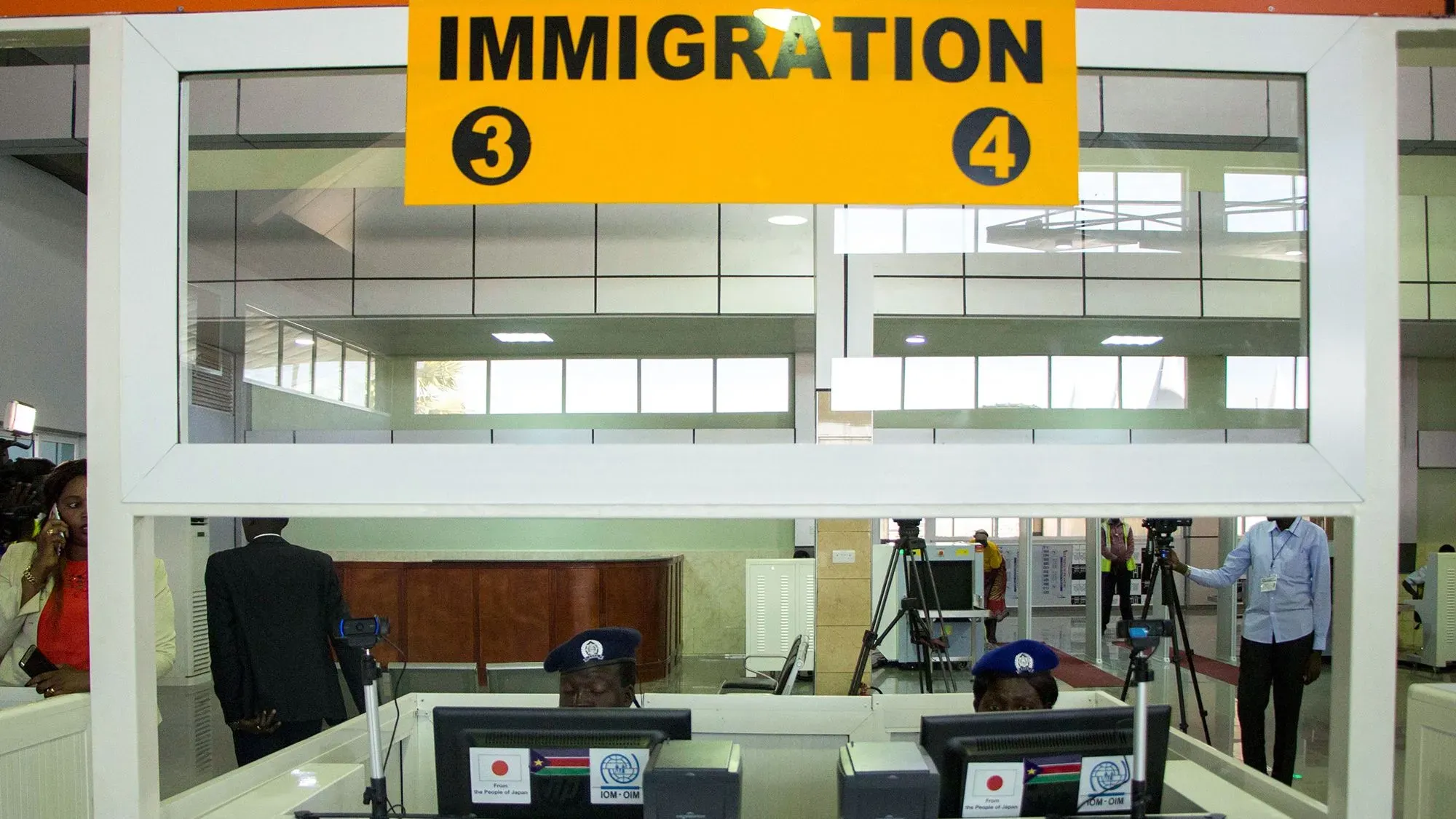 مكتب الهجرة في مطار جوبا الدولي، حيث يجري تفتيش المسافرين. يشير السياق إلى تحديات الترحيل من الولايات المتحدة إلى جنوب السودان.