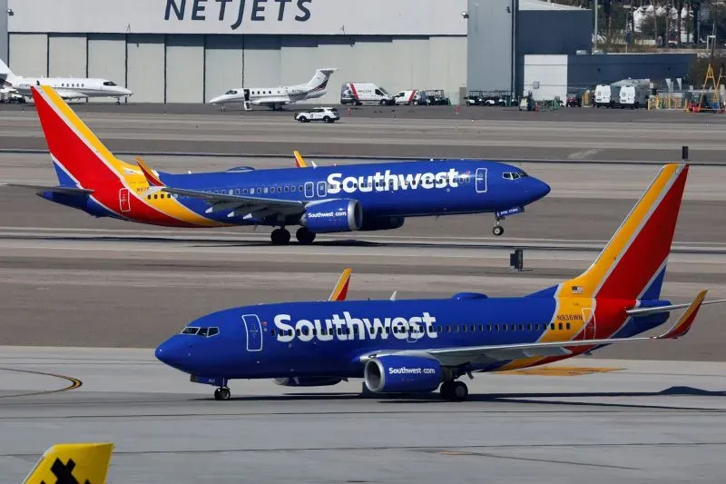 طائرتان لشركة ساوث ويست الجوية على مدرج المطار، مع التركيز على القواعد الجديدة المتعلقة بشحن البطاريات المحمولة أثناء الرحلات.