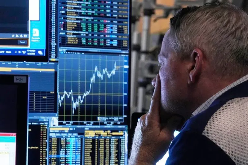 رجل يتأمل شاشات متعددة تعرض بيانات السوق المالية، مع ارتفاع مؤشرات الأسهم الأمريكية وسط تحسن في بيانات الوظائف.