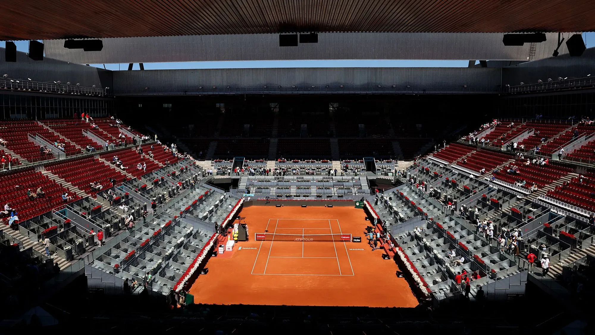 مدرجات فارغة في ملعب تنس مع أرضية ترابية، تعكس حالة من الهدوء بعد انقطاع التيار الكهربائي في إسبانيا والبرتغال.