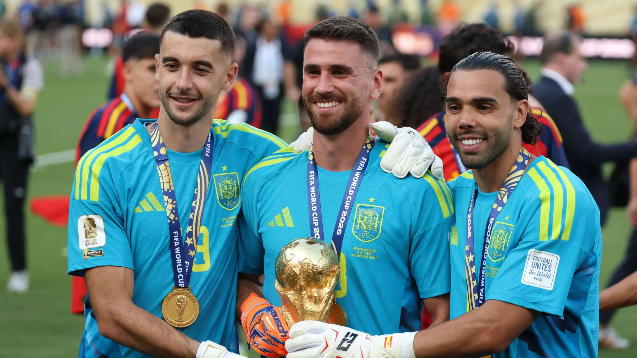 ثلاثة حراس مرمى من منتخب إسبانيا يحملون ميداليات وكأس كأس العالم 2022، يعكسون تفوق إسبانيا في حراسة المرمى وجوائز الكرة الذهبية.