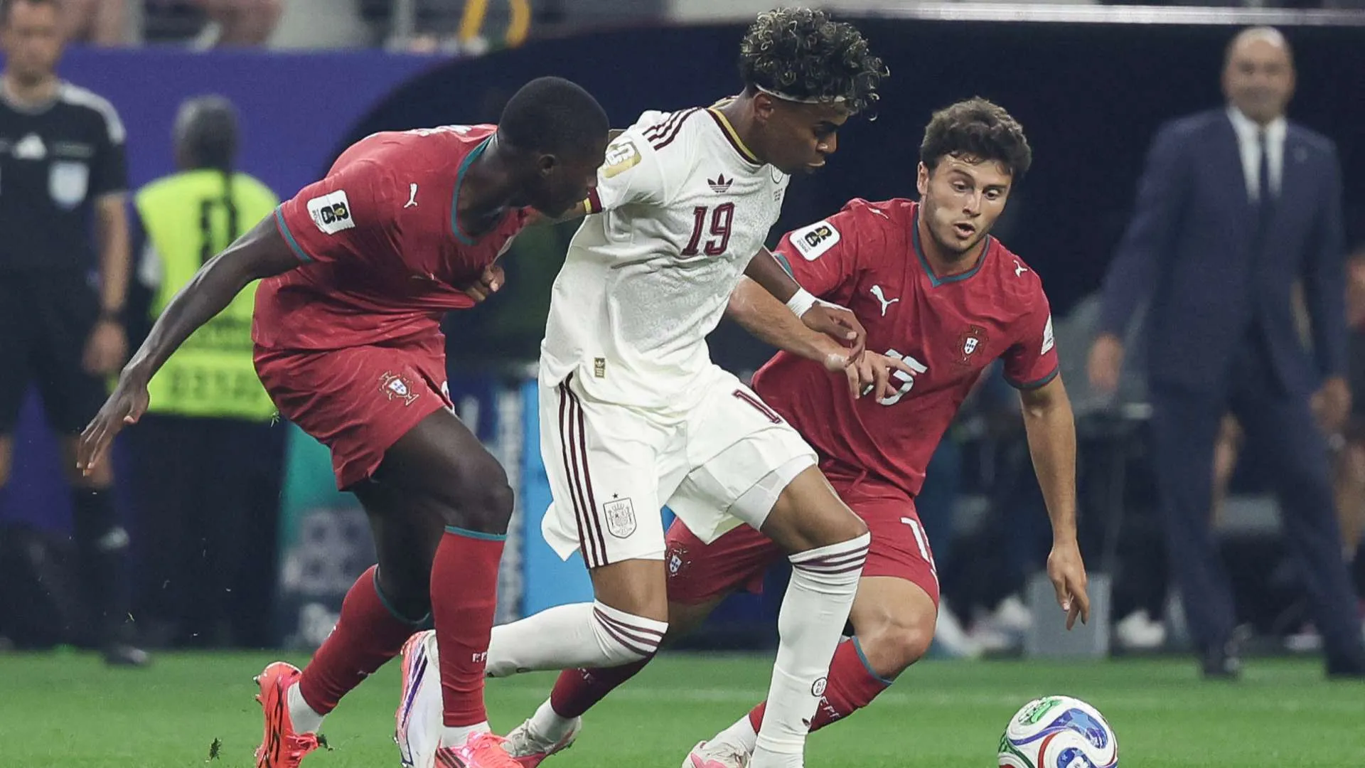 لاعب إسباني يراوغ اثنين من لاعبي البرتغال خلال مباراة كأس العالم في ملعب Dallas Stadium، مع تركيز على الأداء التكتيكي والدفاعي.