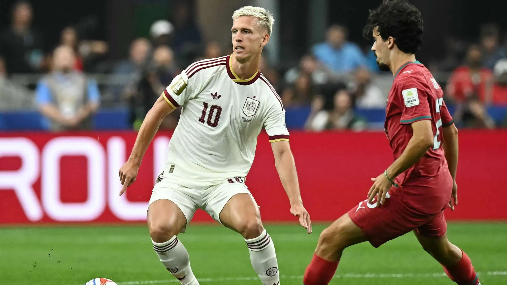 لاعب إسباني يرتدي الرقم 10 يسيطر على الكرة أمام لاعب من البرتغال خلال مباراة كأس العالم في ملعب دالاس.