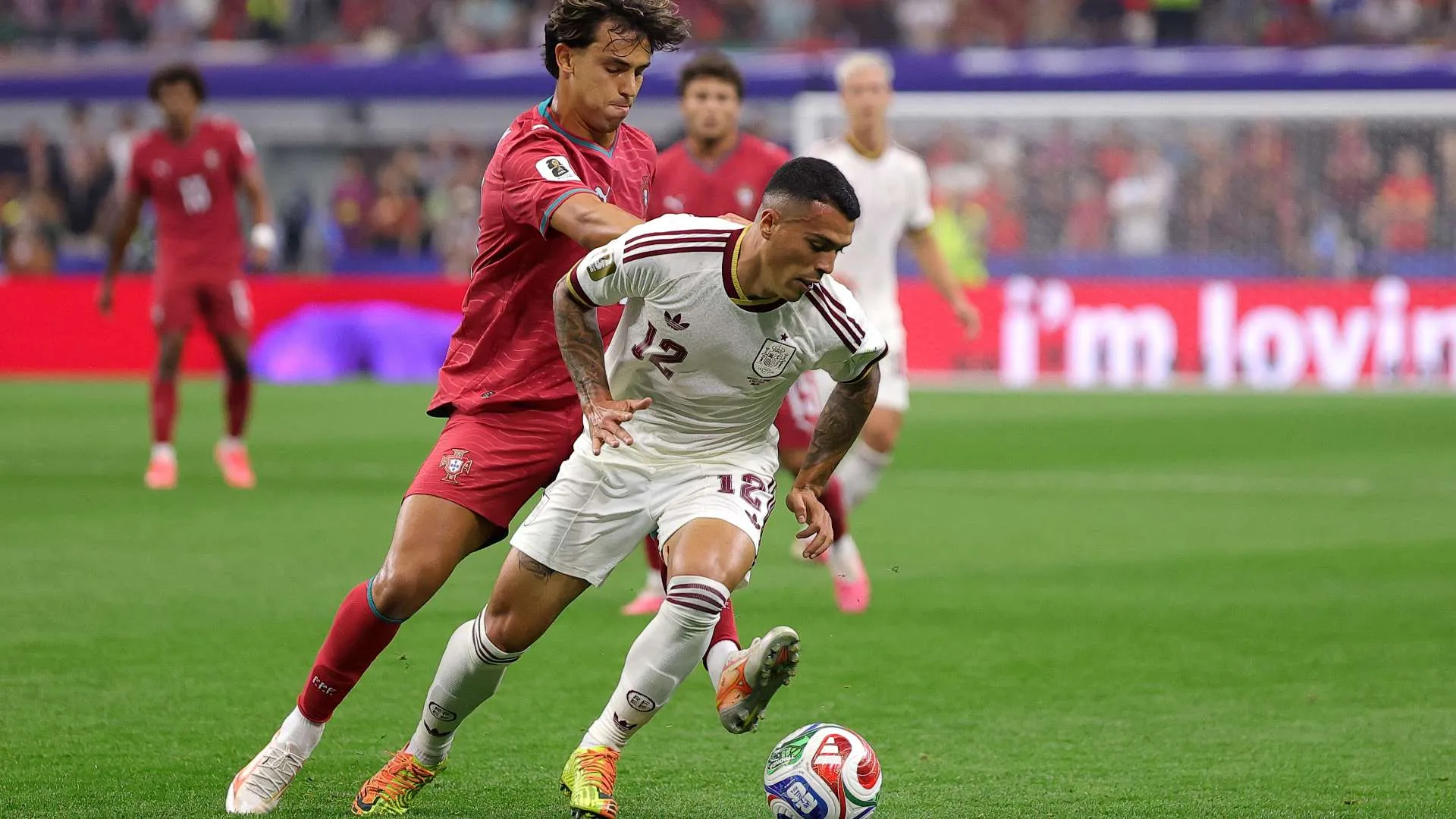 لاعب إسباني يتقدم بالكرة تحت ضغط لاعب برتغالي خلال مباراة كأس العالم في ملعب Dallas Stadium.