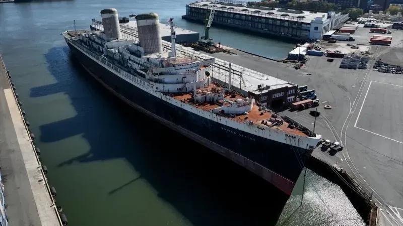 سفينة SS United States ترسو في ميناء فيلادلفيا قبل مغادرتها إلى موبيل، ألاباما، لتصبح شعابًا مرجانية اصطناعية.