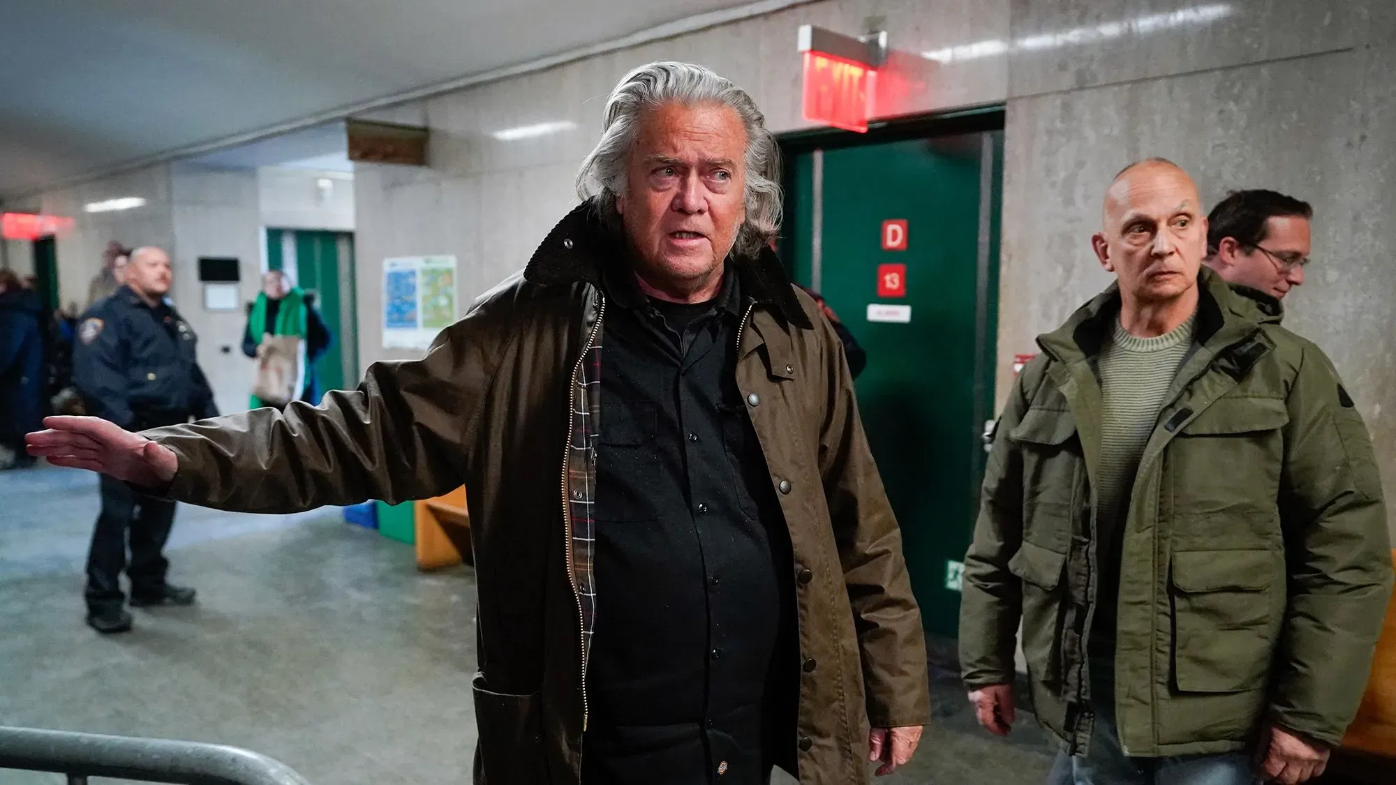 ستيف بانون في قاعة المحكمة، حيث أقر بذنبه في الاحتيال في جهود جمع التبرعات لبناء الجدار، مع وجود رجال آخرين في الخلفية.