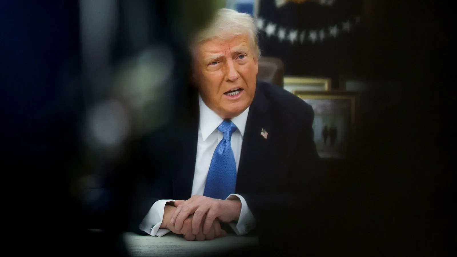 تصريح الرئيس ترامب حول فرض رسوم جمركية جديدة، مع التركيز على تعابير وجهه أثناء حديثه في المكتب البيضاوي.