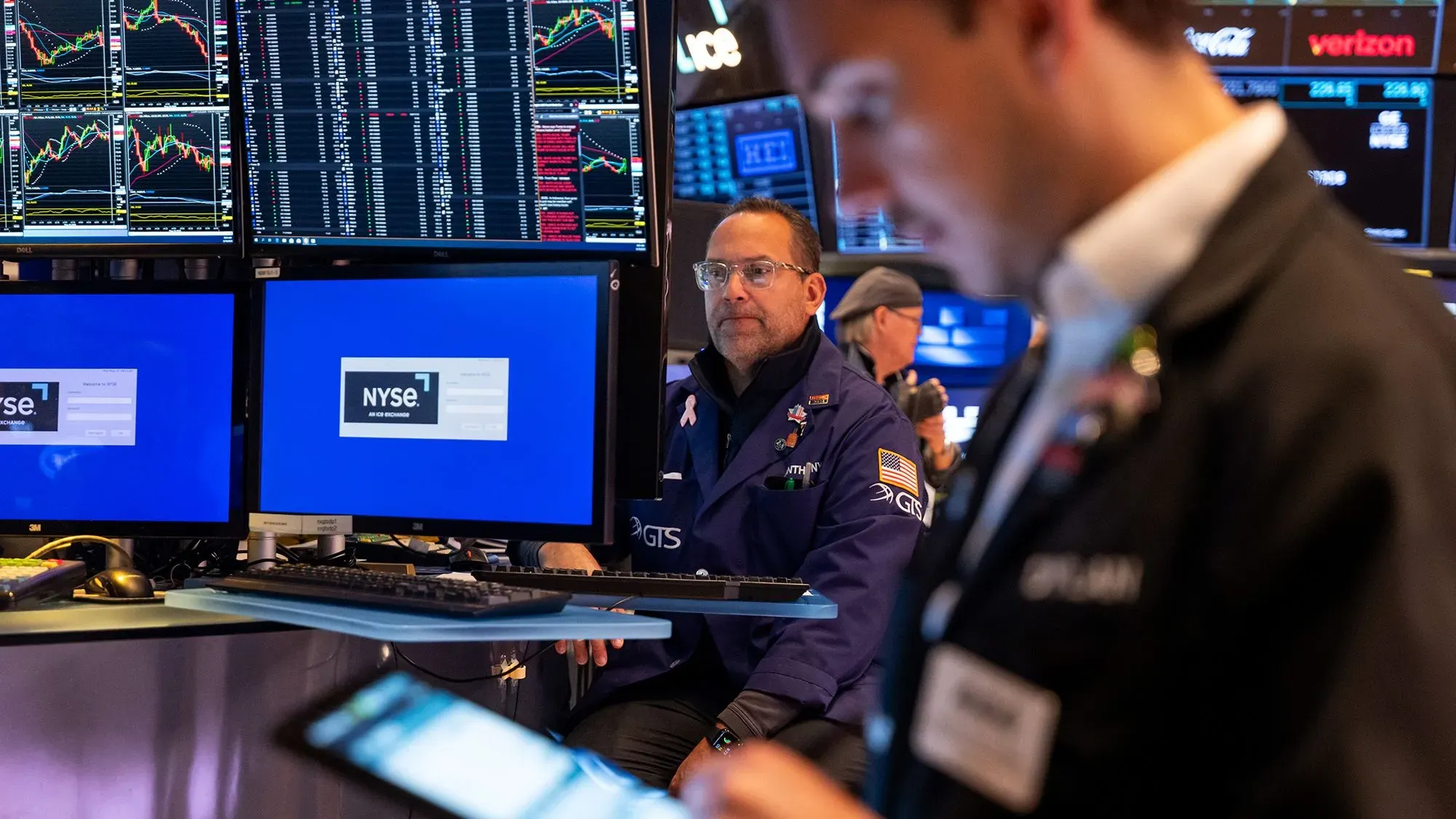 تاجر في بورصة نيويورك يراقب شاشات التداول بينما يرتفع مؤشر الأسهم بعد تأجيل ترامب للرسوم الجمركية على الاتحاد الأوروبي.