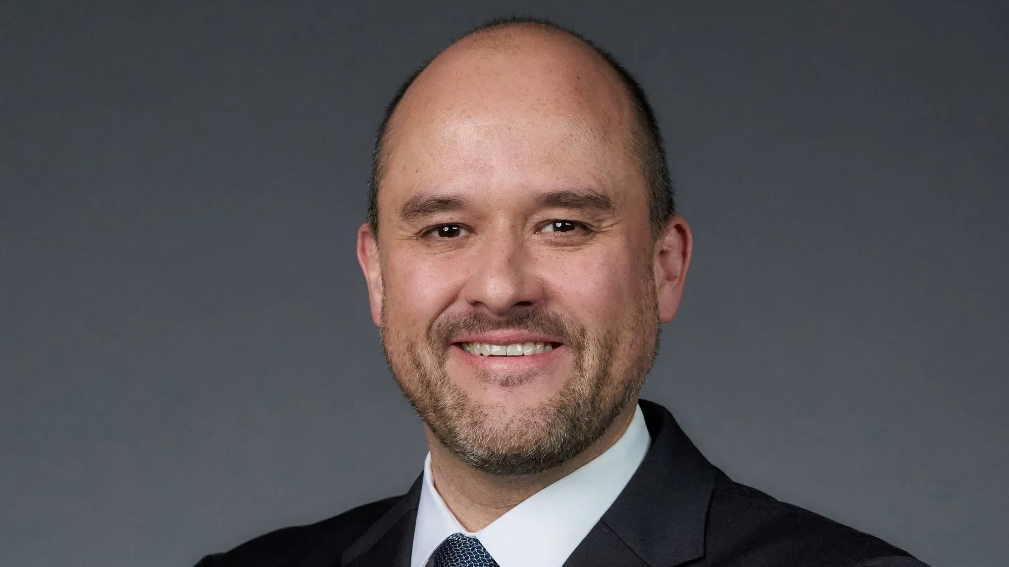 إيفان إسبينوزا، الرئيس الجديد لشركة نيسان، مبتسم في صورة رسمية، حيث يتولى قيادة الشركة وسط تحديات في صناعة السيارات.