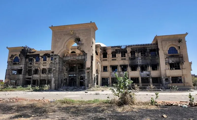 مبنى حكومي في الخرطوم متضرر بشدة من الصراع، يظهر آثار الدمار والنيران، مما يعكس الأثر المدمر للصراع في السودان.