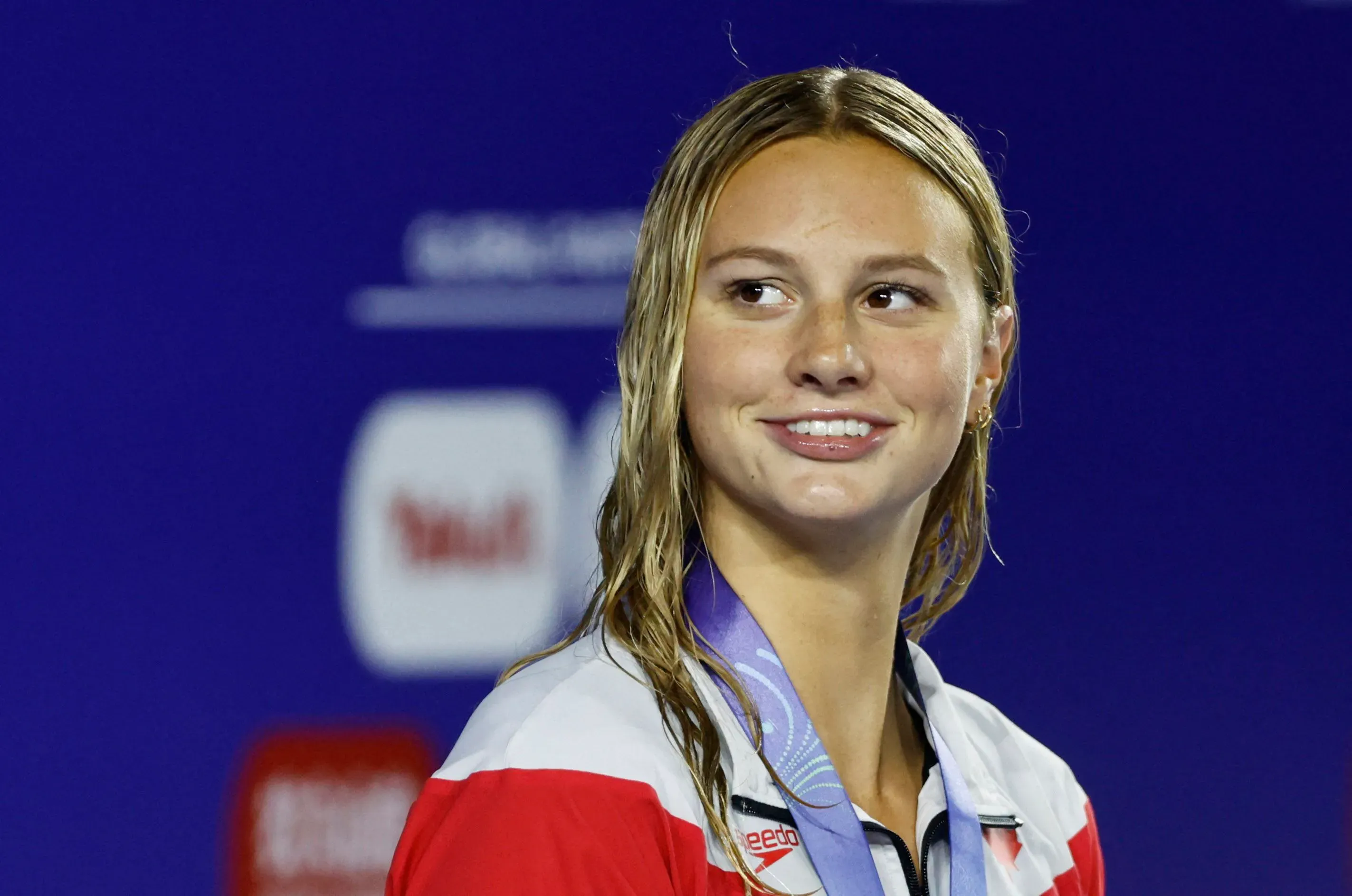 سمر ماكينتوش، السباحة الكندية، تبتسم بفخر بعد فوزها بميدالية ذهبية في بطولة العالم للألعاب المائية في سنغافورة.