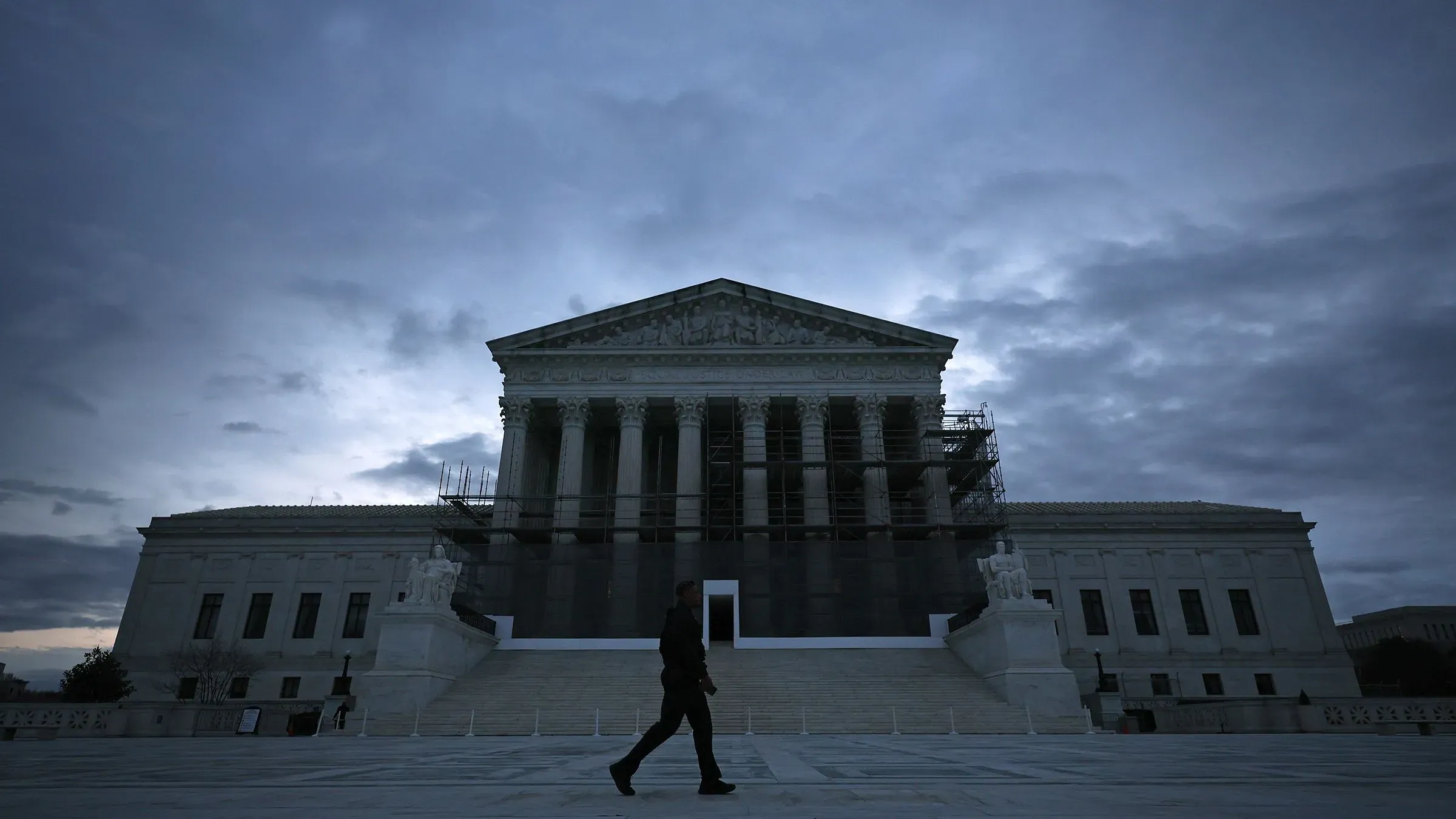 المشي أمام المحكمة العليا الأمريكية في أجواء غائمة، مع وجود أعمال ترميم واضحة على المبنى.