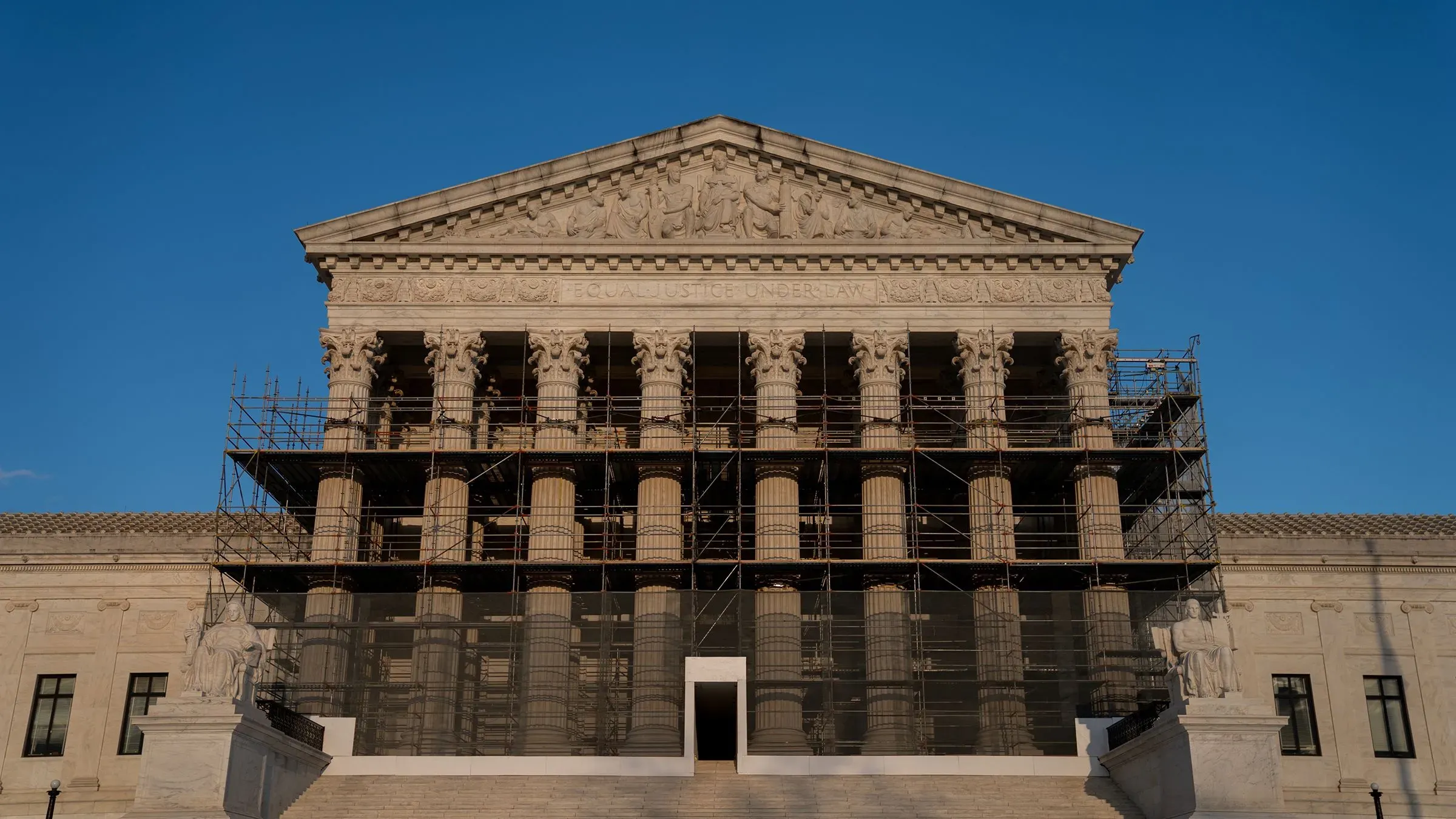 واجهة المحكمة العليا الأمريكية محاطة بالسقالات، مع أعمدة مزخرفة وأعمال ترميم، تعكس أهمية القرارات القانونية المتعلقة بقضايا العمل.