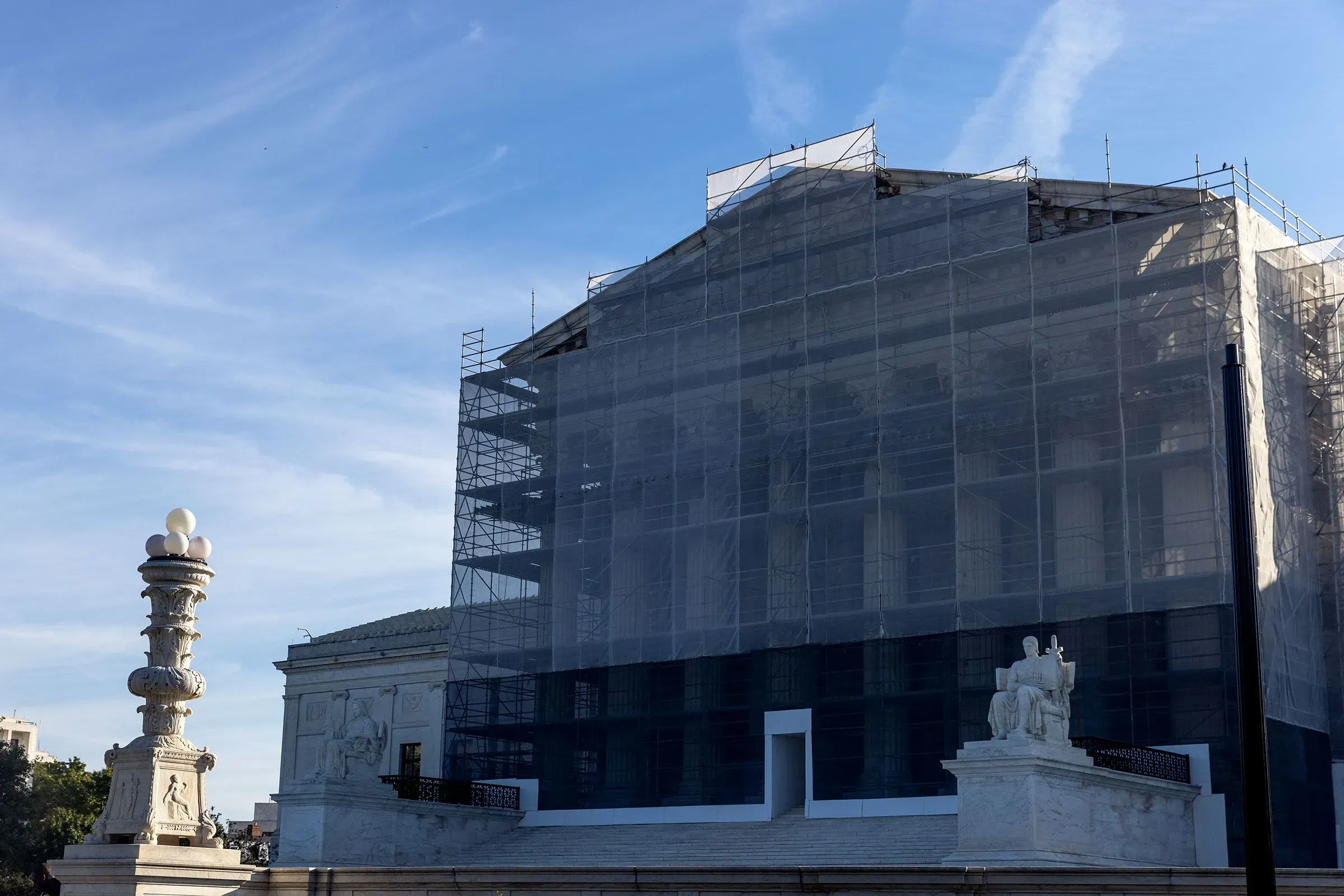 واجهة المحكمة العليا مغطاة بشبكات الحماية، مع تمثال يُظهر شخصية تمثل العدالة، في سياق مناقشات حول نشر الحرس الوطني.