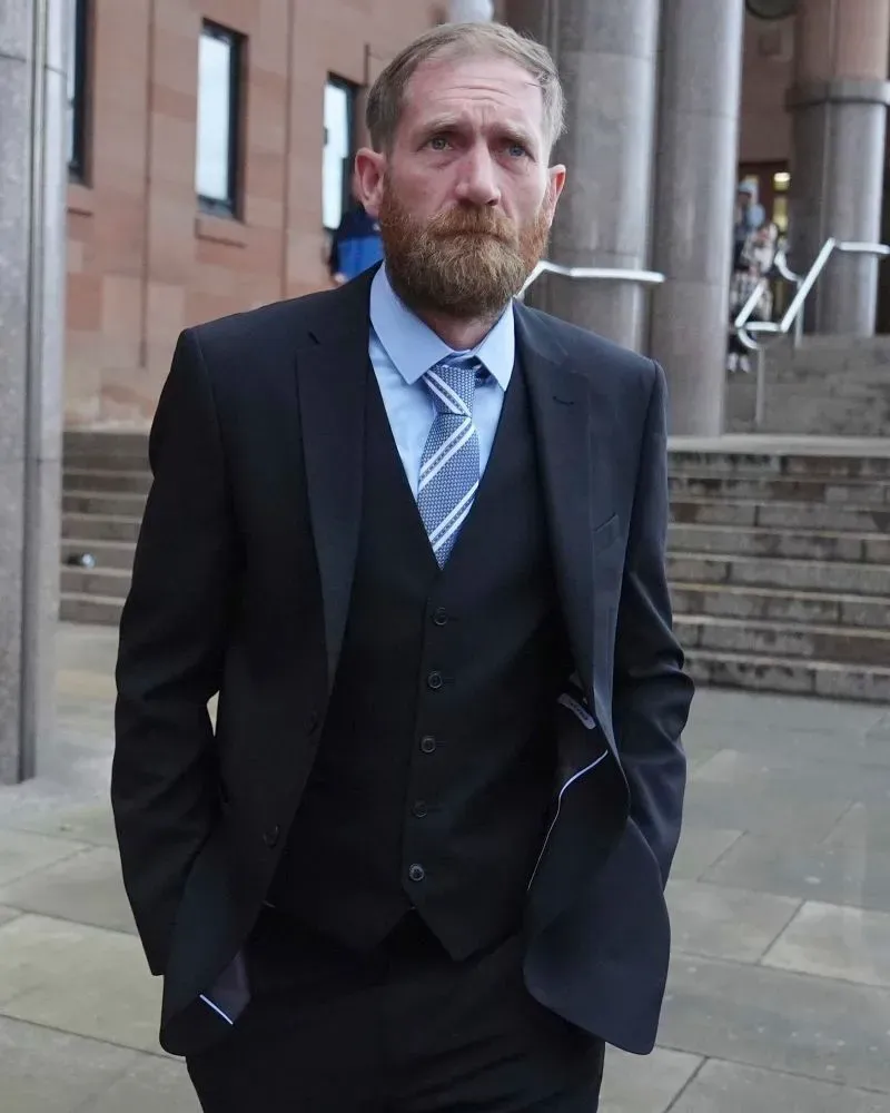 رجل يرتدي بدلة رسمية يسير خارج المحكمة، حيث تم إدانته بتهمة الإضرار بشجرة جميز تاريخية في شمال إنجلترا.