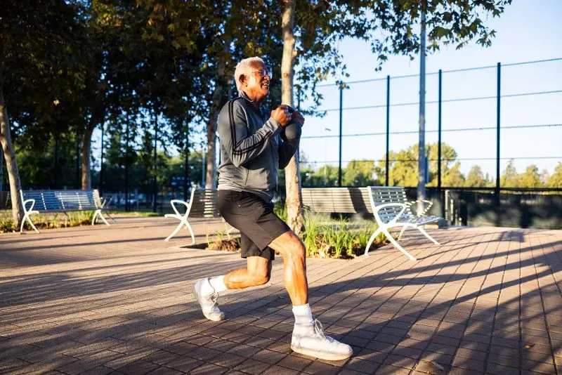 رجل مسن يمارس تمارين القوة في حديقة، مما يعزز صحته البدنية والعقلية، في إطار نصائح للحفاظ على صحة الدماغ.