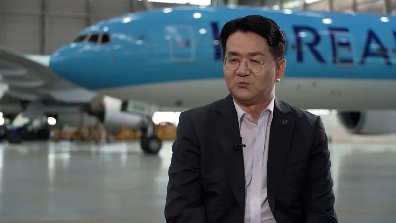 الرئيس التنفيذي للخطوط الجوية الكورية، والتر تشو، يتحدث عن تأثير الحرب التجارية على الشركة، مع طائرة بوينغ 777 خلفه.