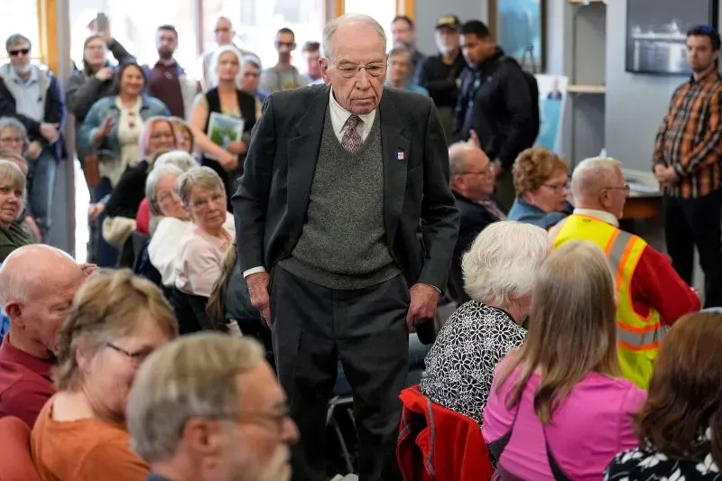 اجتماع حاشد لمؤيدي الحزب الجمهوري في قاعة بلدية، حيث يظهر السناتور تشاك غراسلي وسط مجموعة من الناخبين الغاضبين.