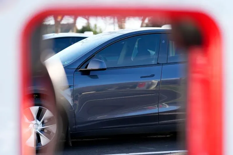 سيارة تسلا موديل 3 تظهر من خلال إطار أحمر، مما يعكس القلق المتزايد بشأن حوادث التخريب وتأثيرها على أقساط التأمين.