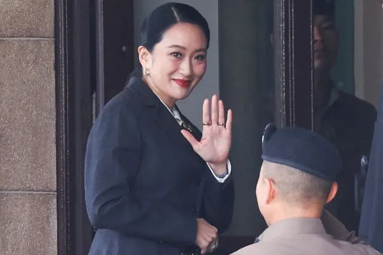 بايتونغتارن شيناواترا، رئيسة وزراء تايلاند الموقوفة، تلوح بيدها أثناء مغادرتها المحكمة بعد صدور حكم بإقالتها بسبب سوء السلوك الأخلاقي.