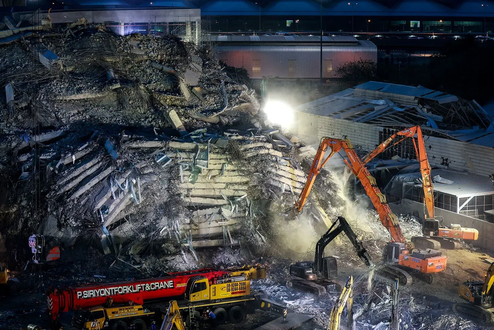 أنقاض مبنى منهار في بانكوك، مع وجود آلات ثقيلة تعمل في الموقع، بعد انهيار البرج نتيجة زلزال قوي.