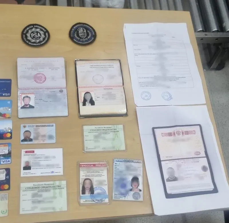 مستندات هوية وأوراق رسمية على طاولة، تشمل جوازات سفر وبطاقات ائتمان، تعود لأفراد مرتبطين بجماعة الأشرم شامبالا.