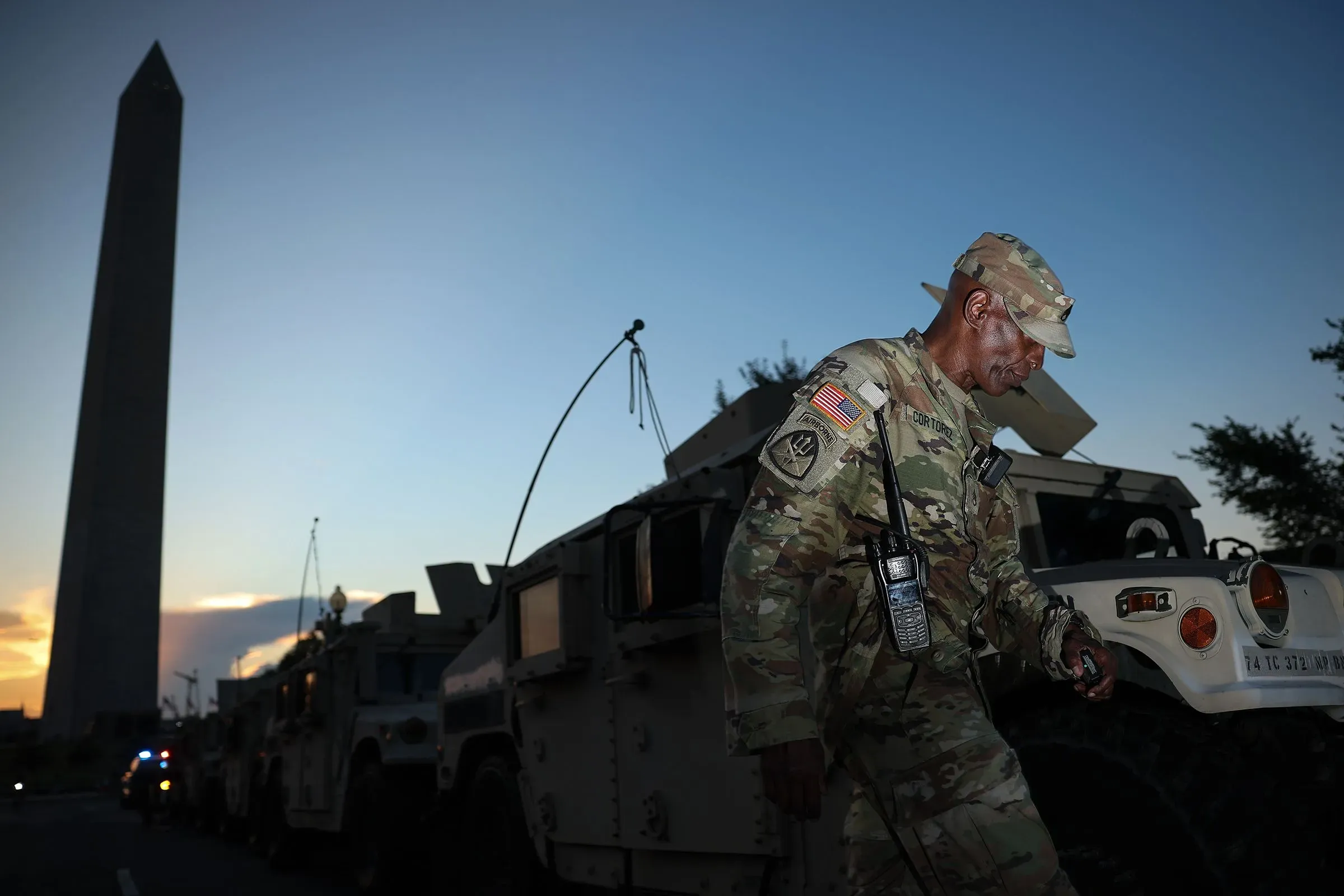 جنود يرتدون زيًا عسكريًا بالقرب من مركبات عسكرية تحت نصب واشنطن، في سياق جهود ترامب لتعزيز إنفاذ القانون في المدن الكبرى.