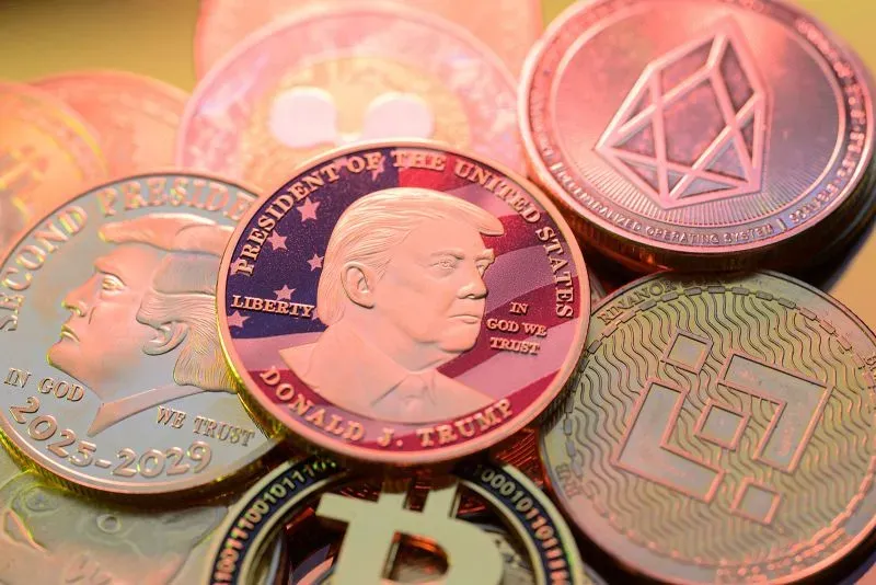 عملة تحمل صورة دونالد ترامب مع رموز لعملات رقمية شهيرة، تعكس اهتماماته في إنشاء احتياطي استراتيجي للعملات الرقمية في الولايات المتحدة.